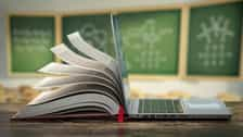 E-learning online education or internet  encyclopedia concept. Open laptop and book compilation in a classroom. (1)